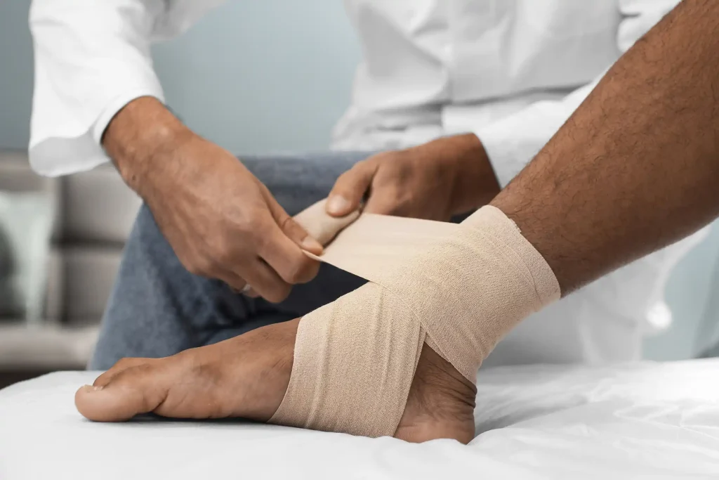 Doctor bandaging a sprained ankle
